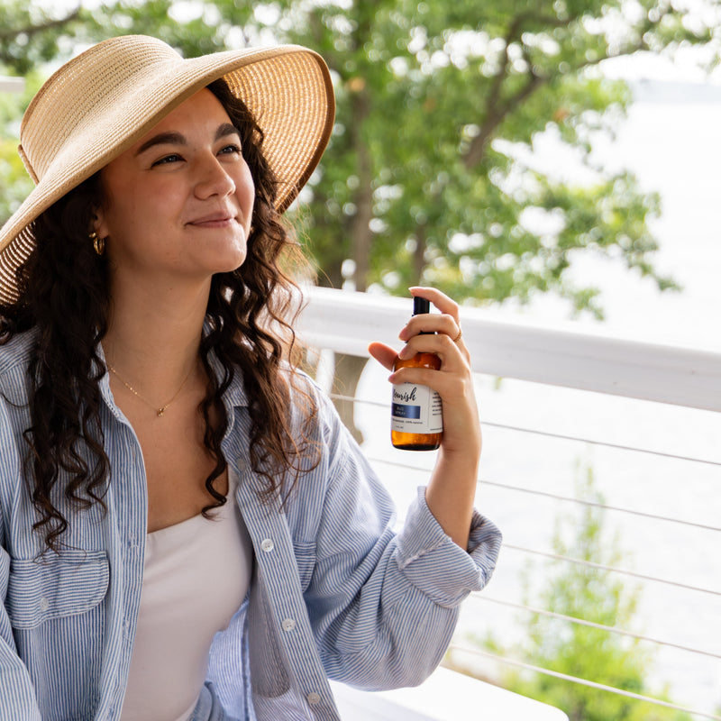 Woman spraying bug spray onto neck