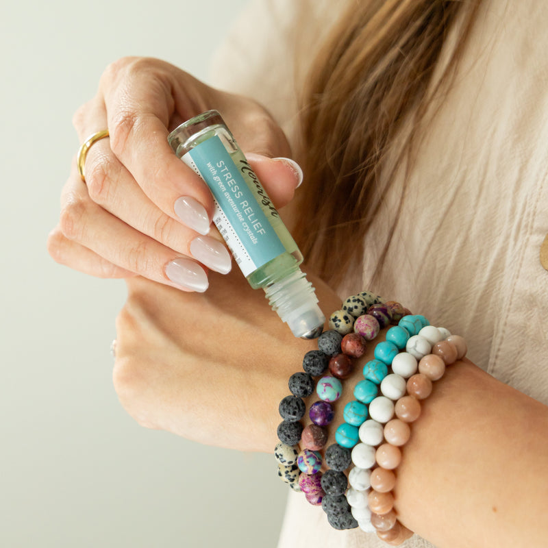 Person applying Stress Relief Blend to bracelets 