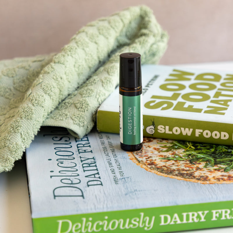 Digestion Roller Blendon a book titled 'Deliciously Dairy Free' with a green towel.