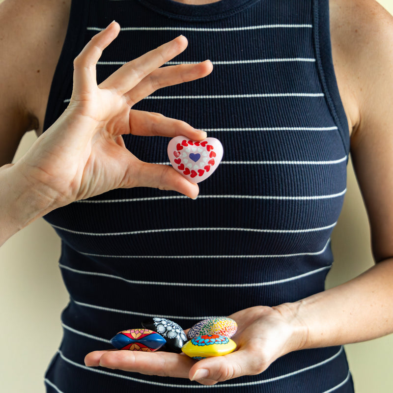 Person holding colorful Mandala Chime Heart in front of their chest