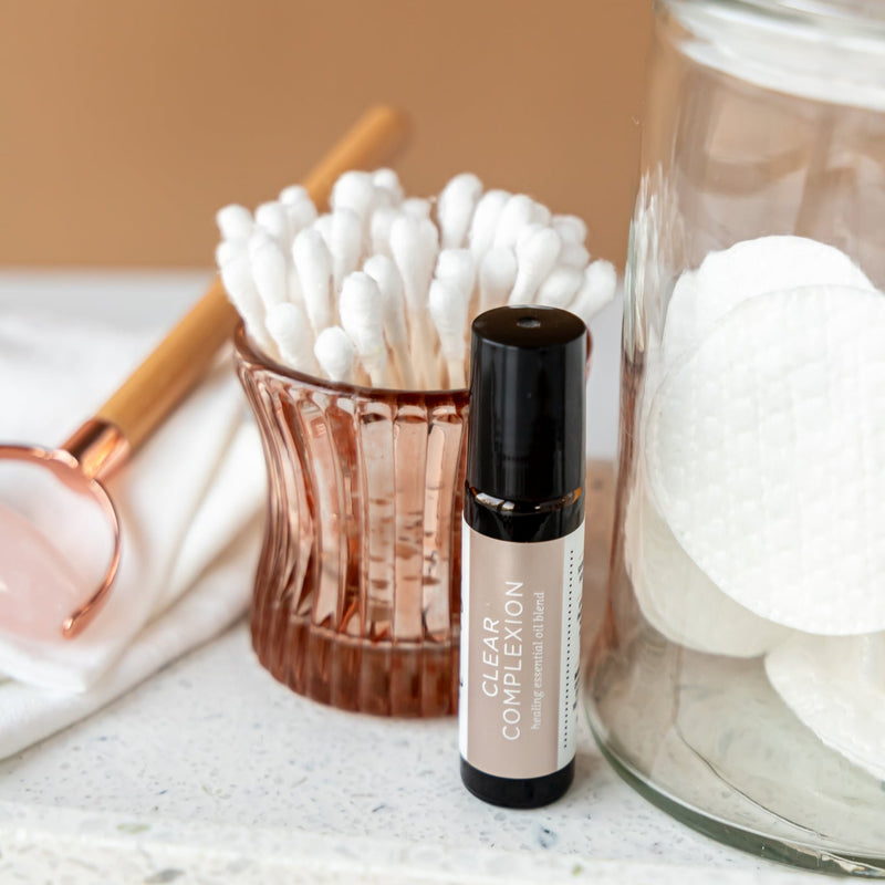 Clear Complexion Blend with cotton swabs and a jar on a textured surface.