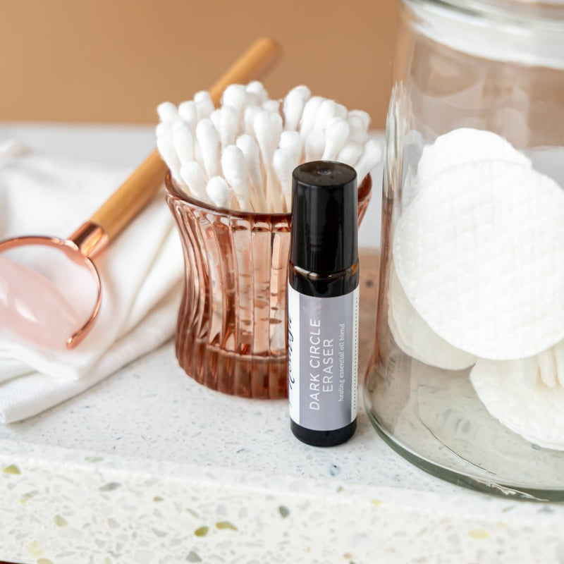 Dark Circle Eraser on a marble surface with skincare items.