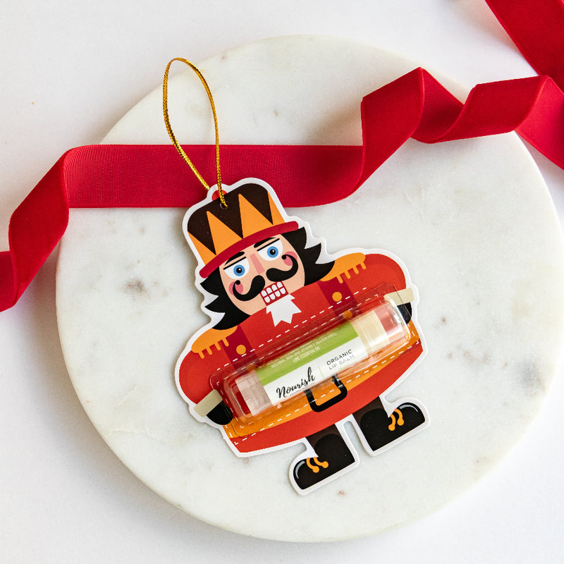 Decorative Nutcracker ornament with a red ribbon on a marble surface